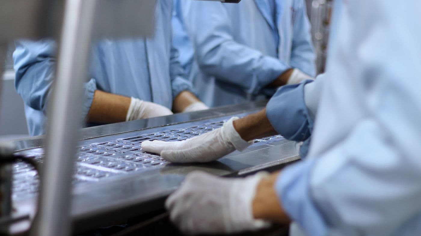Gloved hands working at a production line